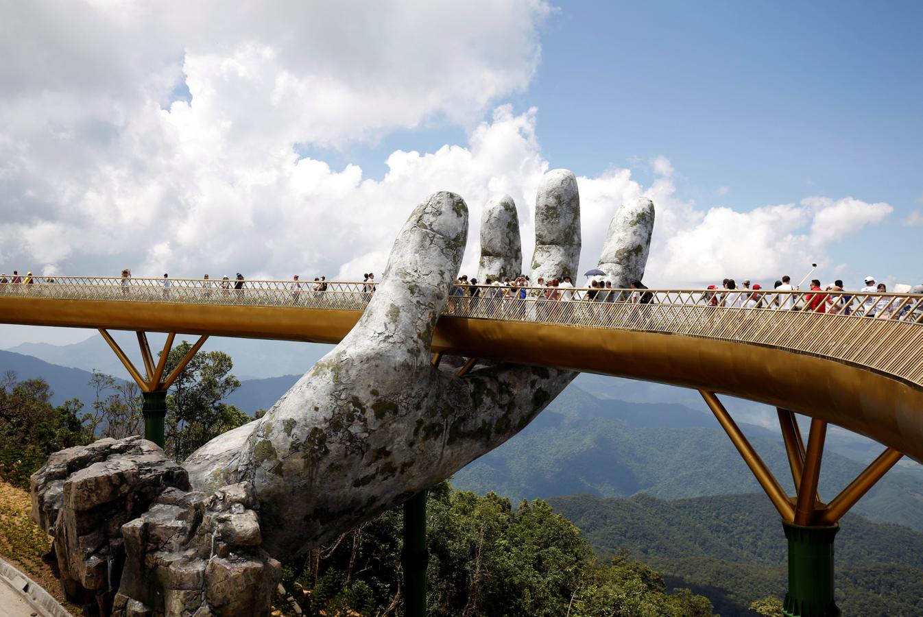 Dos manos gigantes sostienen un nuevo puente en Vietnam. El nuevo y espectacular puente, construido en Da Nang, fue inaugurado en junio. La pasarela peatonal, diseñado por TA Landscape Architecture en Ho Chi Minh, se sitúa en más de 1.000 metros sobre el nivel del mar