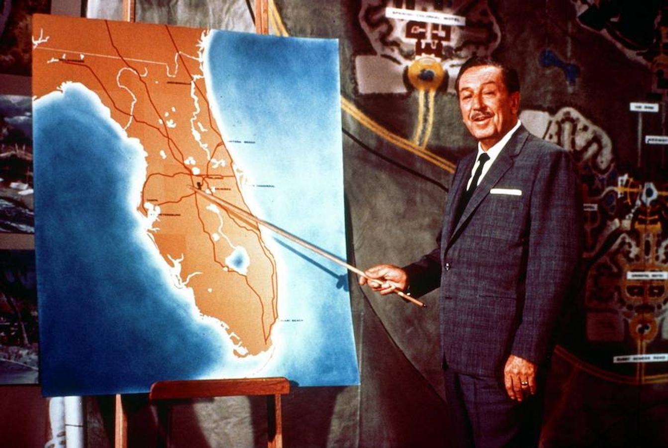 Walt Disney señala en un mapa Florida, lugar de creación del parque temático de Disney de Orlando. 