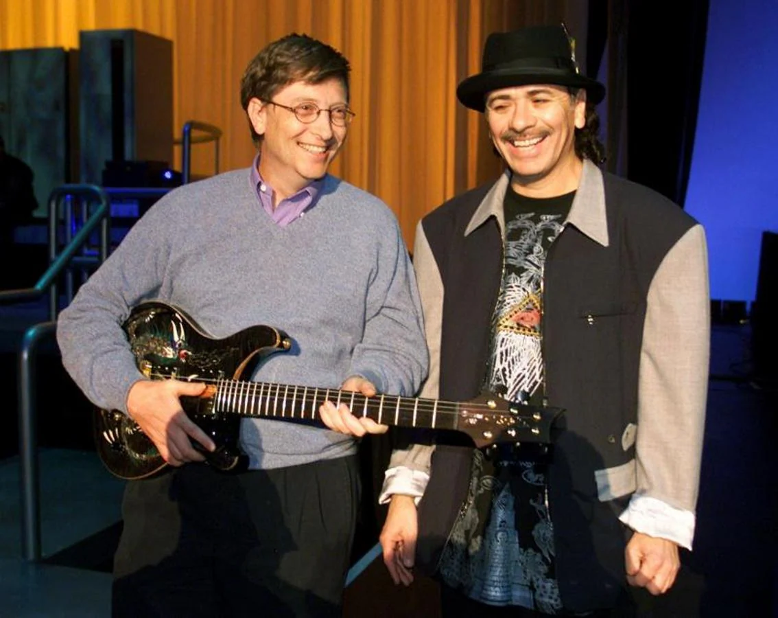 Bill Gates sostiene una guitarra junto al guitarrista Carlos Santana. 
