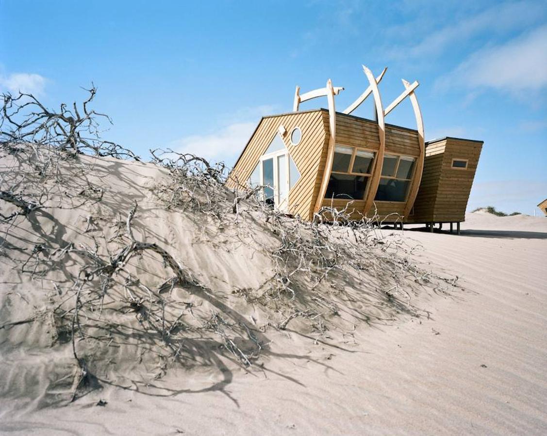 Cabañas de madera de Shipwreck Lodge. Las cabañas evocan los barcos varados entre el desierto y el océano de Namibia