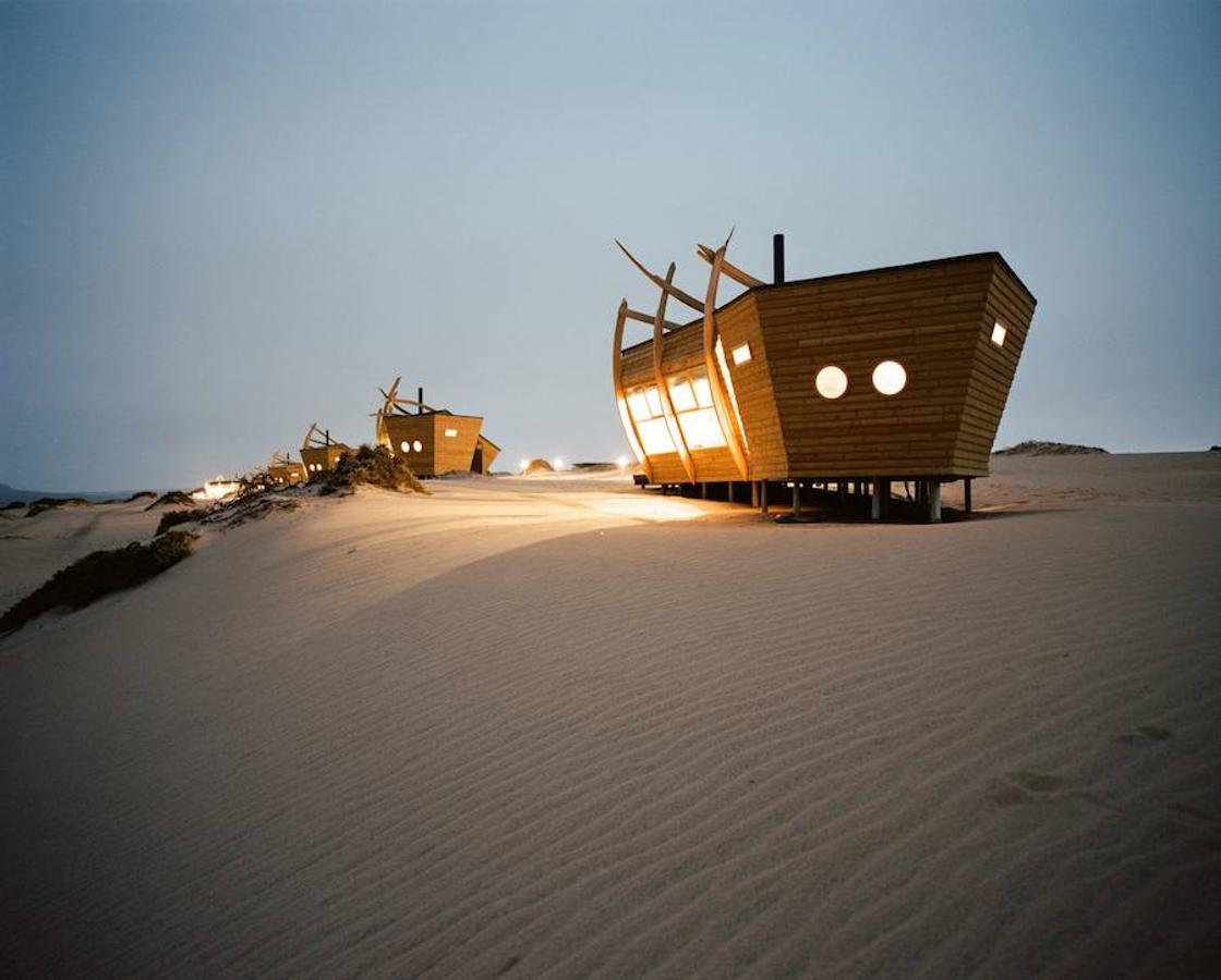 Cabañas de madera de Shipwreck Lodge. Las cabañas evocan los barcos varados entre el desierto y el océano de Namibia