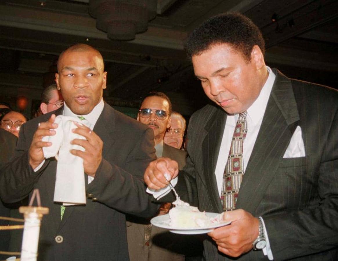 Ali comiéndose su tarta de cumpleaños en presencia de Mike Tyson. 