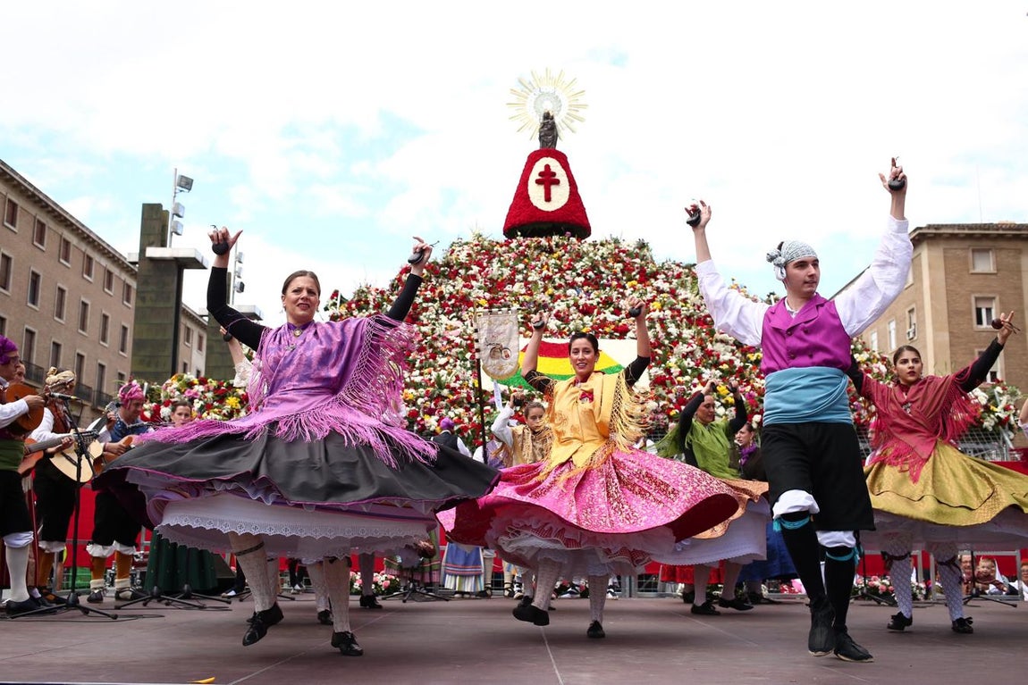 De sol a sol. La Ofrenda arrancó cuando aún no había amanecido y se ha prolongado cuando había caído la noche sobre Zaragoza. Arriba, un grupo jotero bailando ante la imagen de la Virgen mientras se tejía su enorme manto de flores.