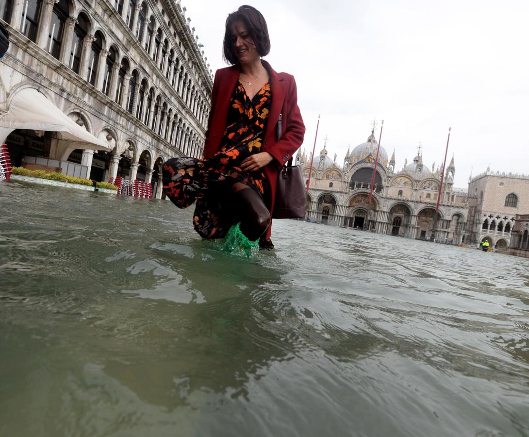Una turista pasea por la plaza de San Marcos, totalmente inundada, en Venecia.. 