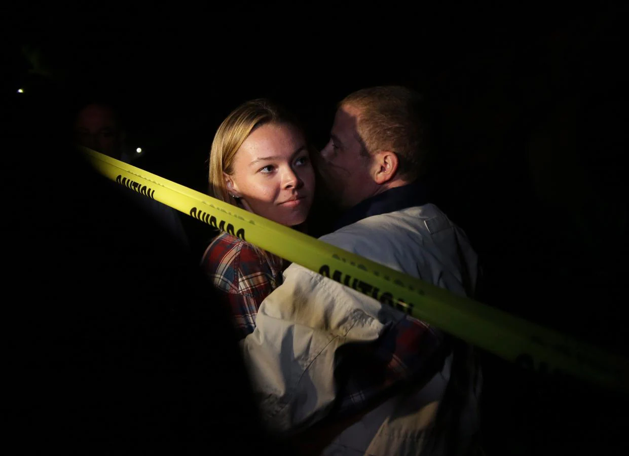 Teylor Whittler (izq) abraza a su padre tras huir del lugar del tiroteo.. 