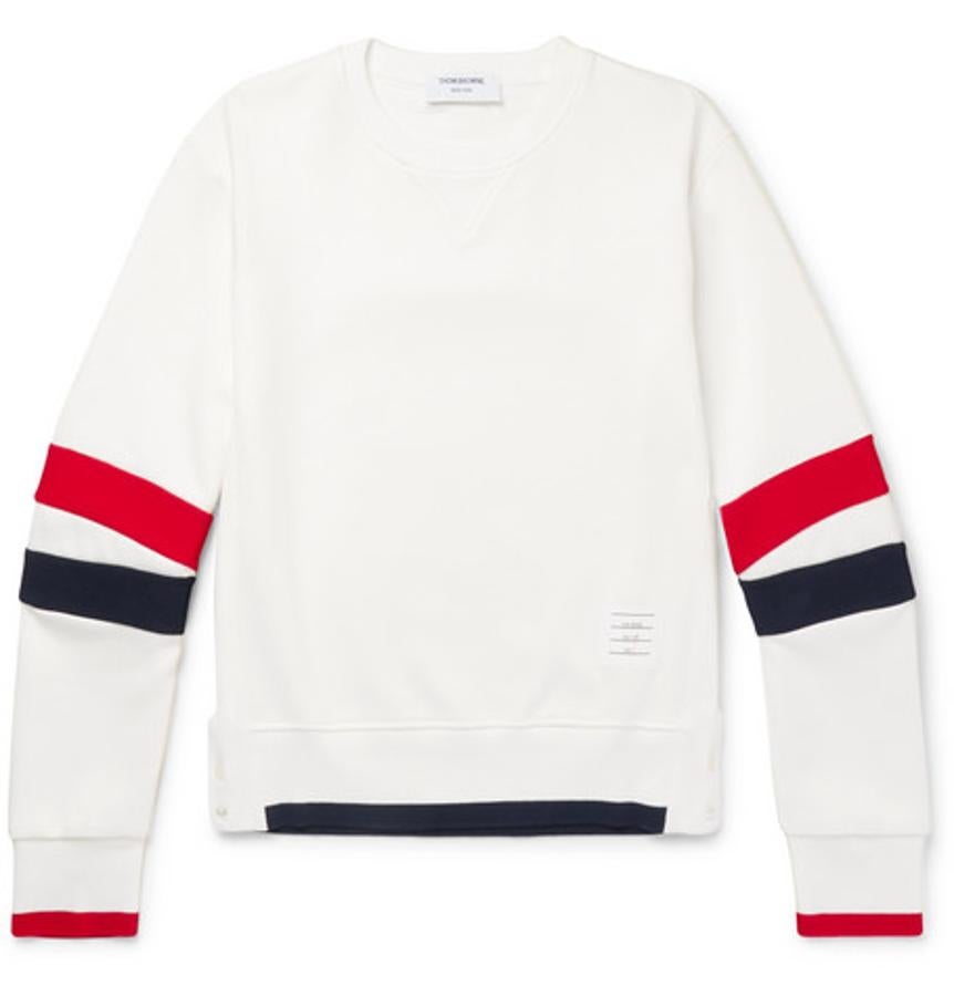 Sudadera de Thom Browne. Las sudaderas blancas son un básico que no siempre sabemos escoger bien, pero ésta de Thom Browne es perfecta porque siendo informal marca los límites con la ropa de gimnasio gracias a las rayas clásicas de la marca. Es una prenda muy versátil que incluso puedes atreverte a llevar con una blazer desestructurada. Precio: 550 euros.