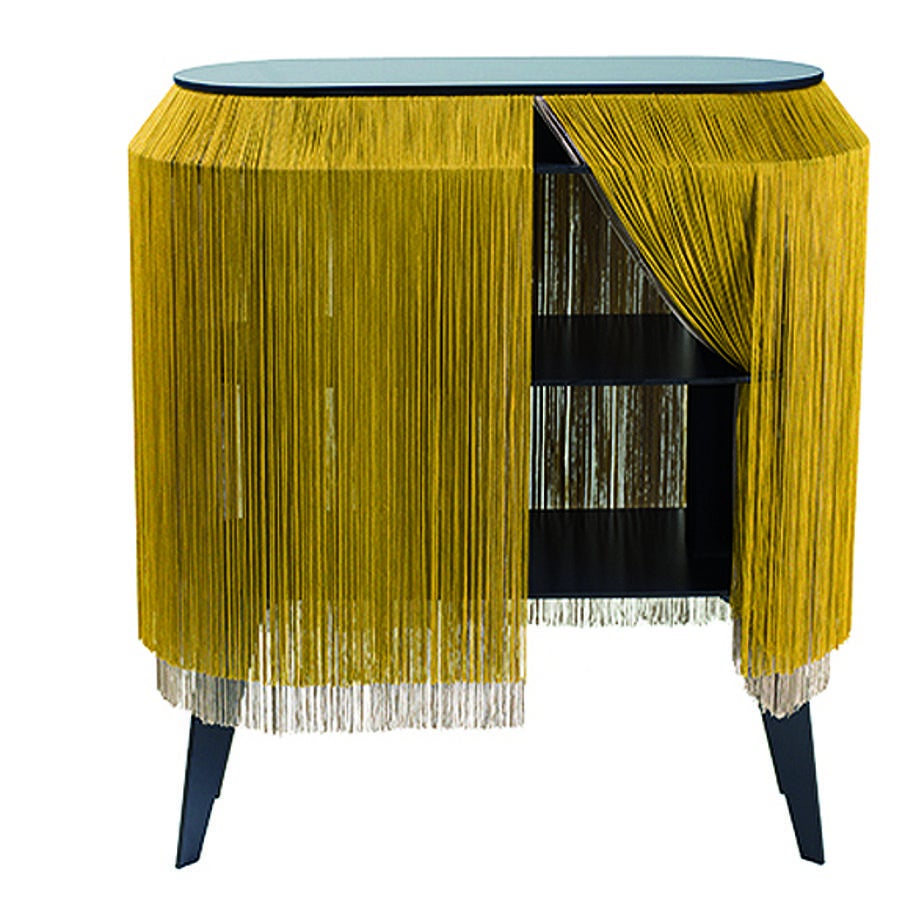 Cómoda de Ibride. Experto en el mundo interior del hogar, esta casa francesa siempre ha destacado por ofrecer un producto completamente diferente al resto del mercado. El mejor ejemplo, esta cómoda-repisa que incorpora los flecos a una propuesta clásica revisitada.