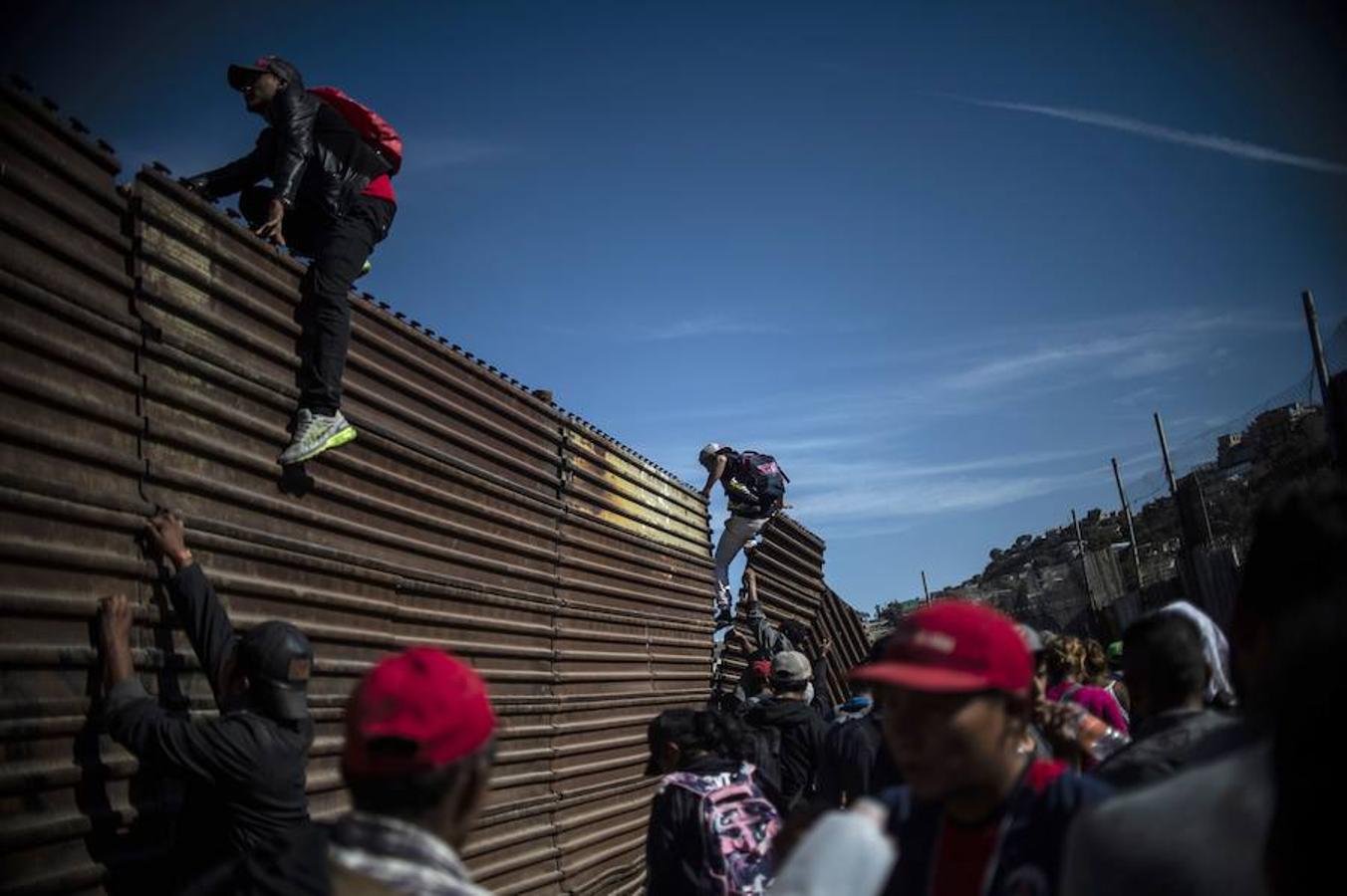 Cientos de inmigrantes tratan de cruzar por la fuerza la frontera entre México y EE.UU. en Tijuana. Los miembros de la caravana rompen el cerco policial y corren para intentar pasar a Estados Unidos