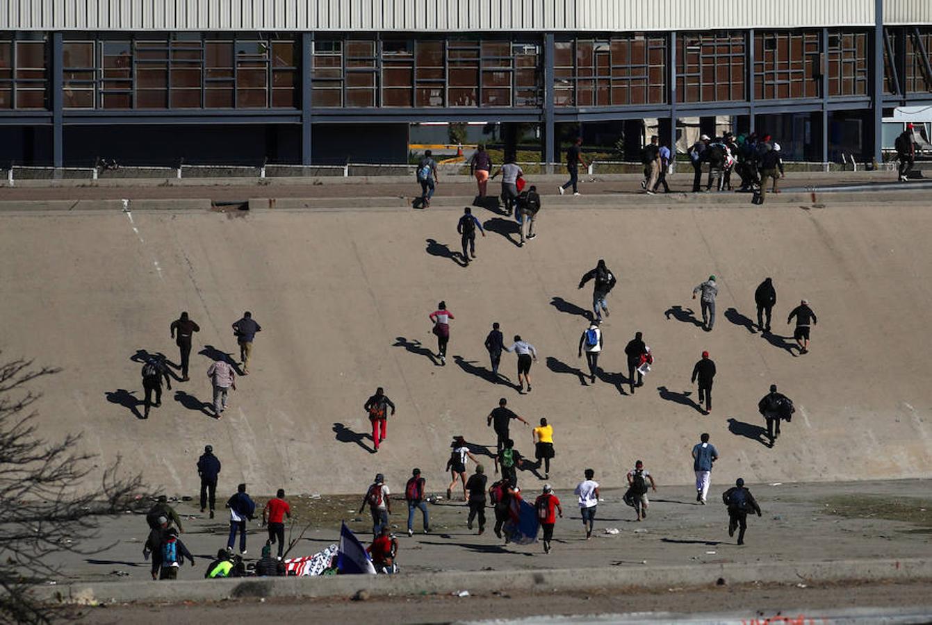 Cientos de inmigrantes tratan de cruzar por la fuerza la frontera entre México y EE.UU. en Tijuana. Los miembros de la caravana rompen el cerco policial y corren para intentar pasar a Estados Unidos