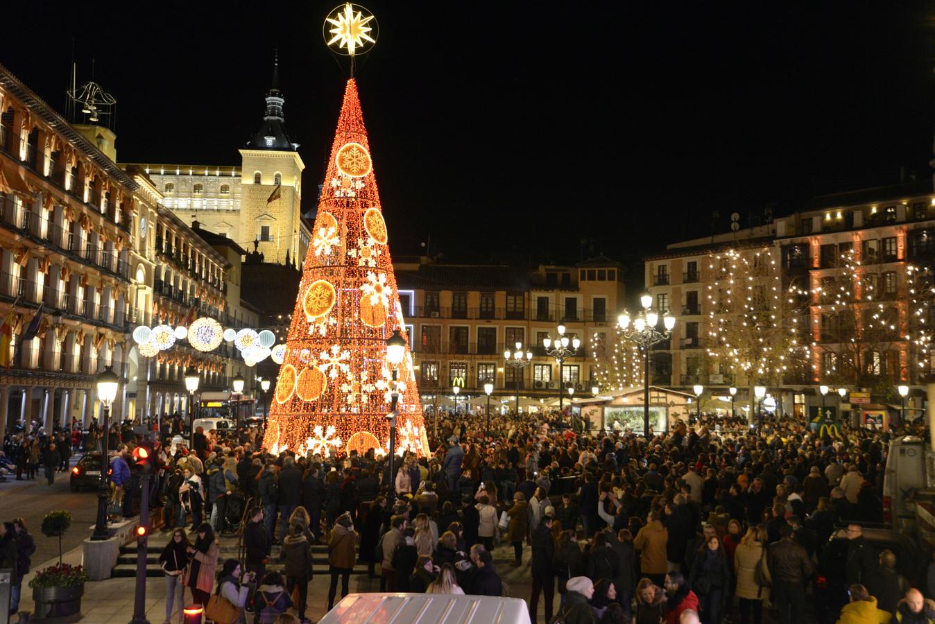 Un enorme abeto de hierro y luces de tonos rojizos emerge del solado de la plaza más famosa de la ciudad, coronado por la estrella de Belén. 