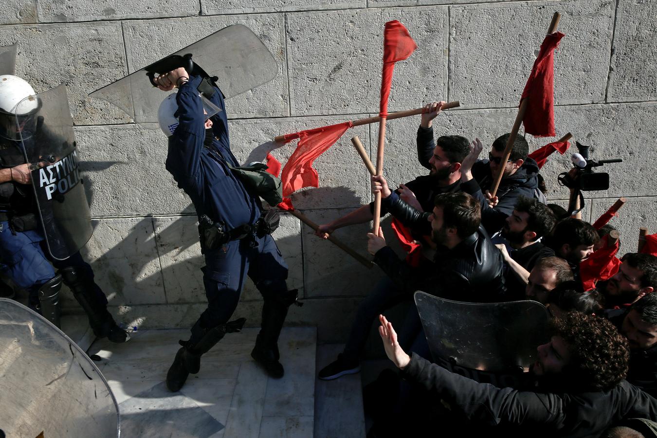 Los manifestantes se enfrentan a la policía antidisturbios durante una manifestación frente al edificio del Parlamento contra las reformas gubernamentales planificadas en Atenas, en Grecia, el 12 de enero de 2018.. 