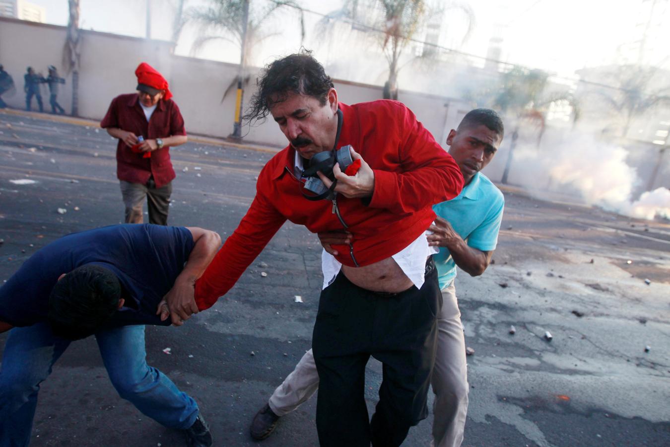 El ex presidente hondureño Manuel Zelaya avanza con dificultad entre gases lacrimógenos durante una protesta contra la reelección del presidente de Honduras, Juan Orlando Hernández, en Tegucigalpa, Honduras, el 12 de enero de 2018.. 