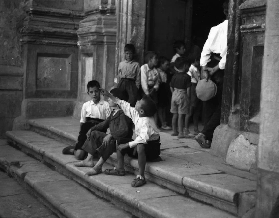 Unos niños esperan durante la misa sentados en la escalinata de la iglesia de San Juan Bautista de Jadraque, en junio de 1937. 