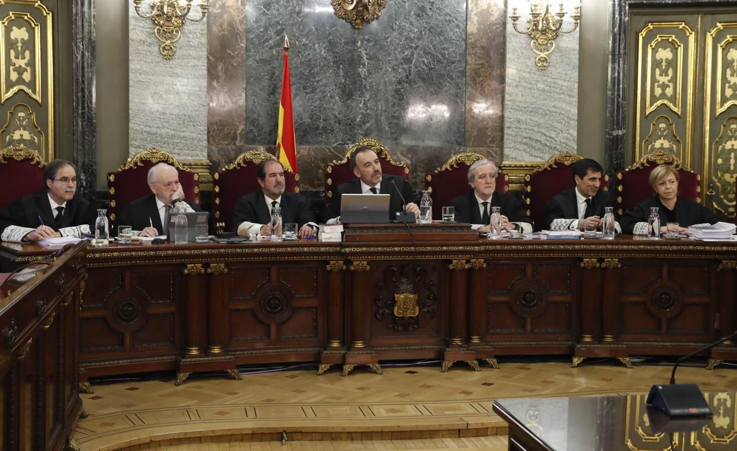 El presidente del tribunal y ponente de la sentencia, Manuel Marchena (c), junto a los magistrados, Andrés Palomo (i), Luciano Varela (2i), Andrés Martínez Arrieta (3i), Juan Ramón Berdugo (3d), Antonio del Moral (2d) y Ana Ferrer (d), en la Sala de Plenos.. 