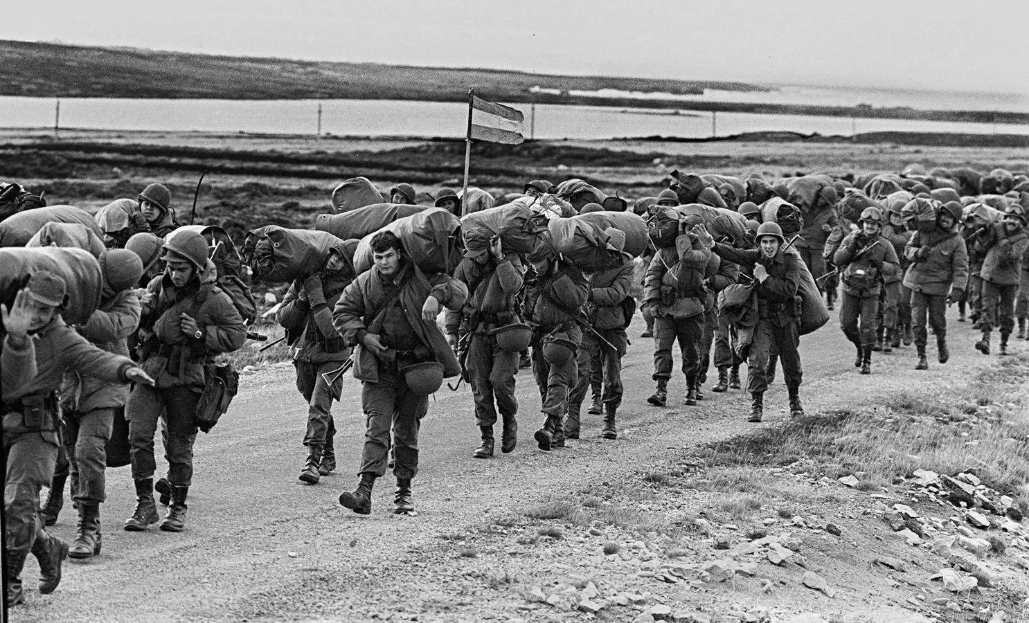 Soldados argentinos caminan el 13 de abril de 1982 para ocupar la base de los Marines Reales capturados en Puerto Argentino/Stanley, unos días después de que la dictadura militar argentina se apoderase de las islas Malvinas, comenzando una guerra entre Argentina y Reino Unido.. 