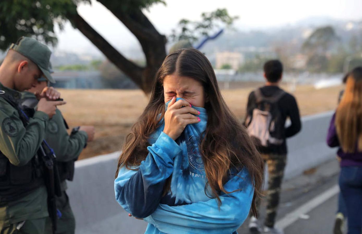 Una mujer reacciona por el gas lacrimógeno en La Carlota. 