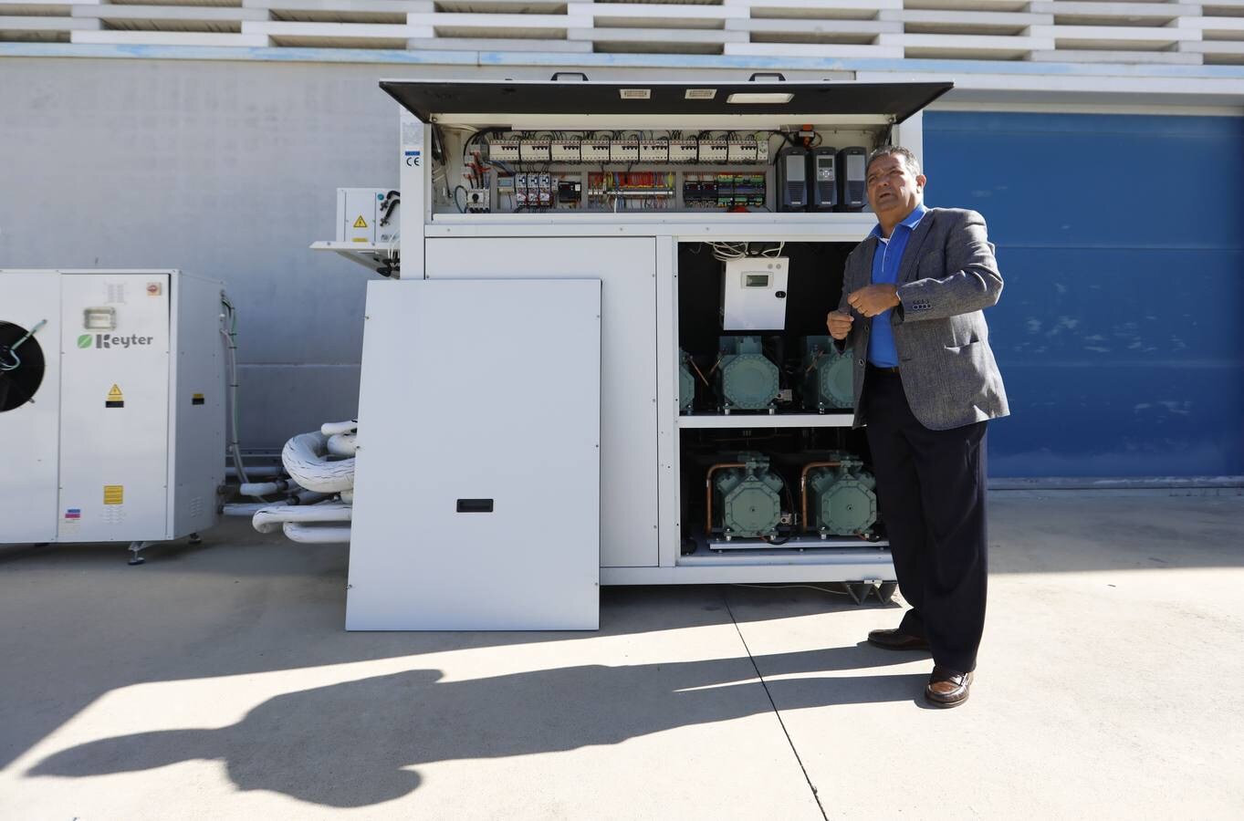 Manuel Servián posa con una de las grandes máquinas climatizadoras en el exterior de la sede de AFAR. Ya lleva varios años en funcionamiento para comprobar su rendimiento en condiciones extremas.