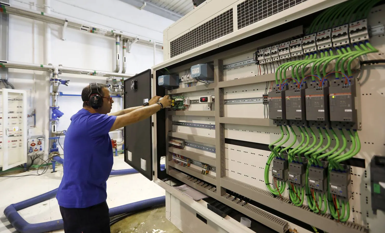 Un operario monta parte de un cuadro eléctrico en una de las grandes máquinas climatizadoras de Intarcon. Son necesarias 5-6 del mismo tamaño para refrigerar una gran superficie comercial.