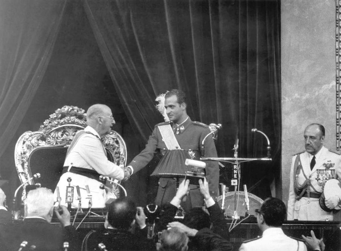 Don Juan Carlos, en la jura de su cargo como sucesor a título de Rey en la Jefatura del Estado, ante las Cortes y junto a Franco.. 