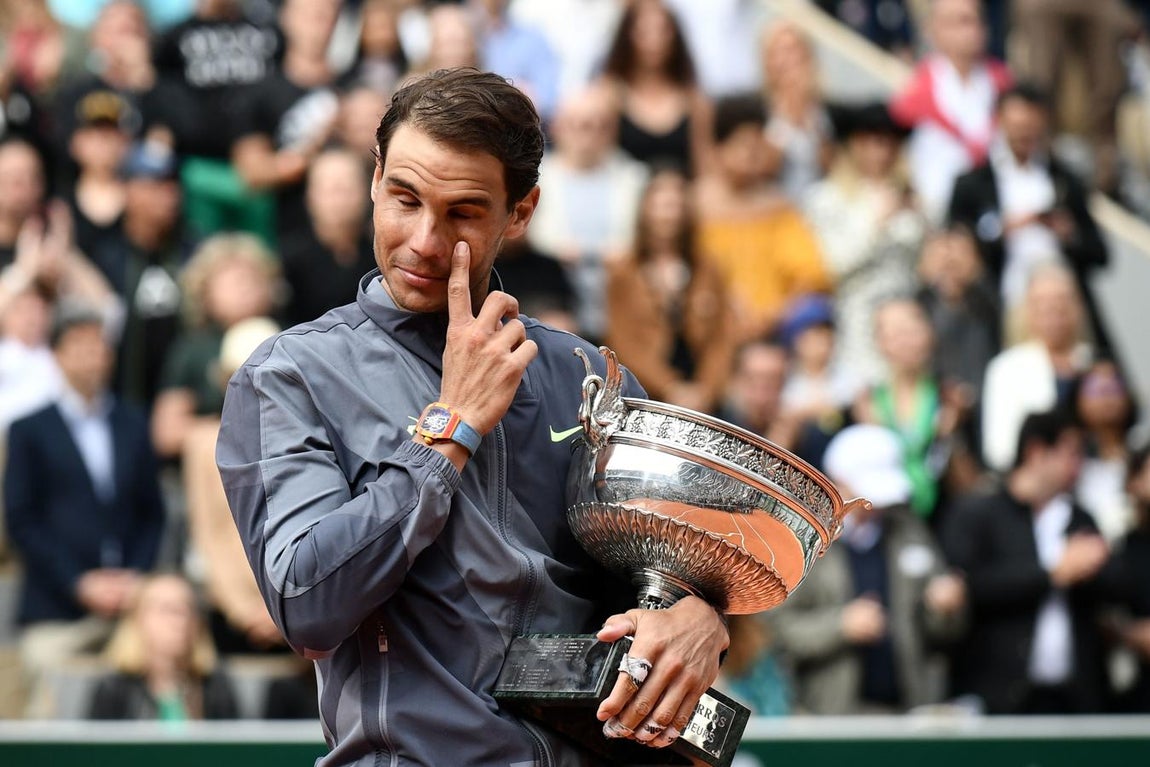 El tenista se seca las lágrimas, con la Copa en el brazo. 