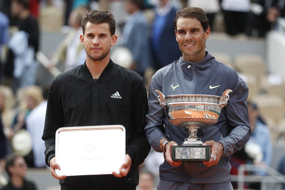 Nadal y Thiem posan tras el encuentro, con el tenista español sosteniendo el trofeo. 