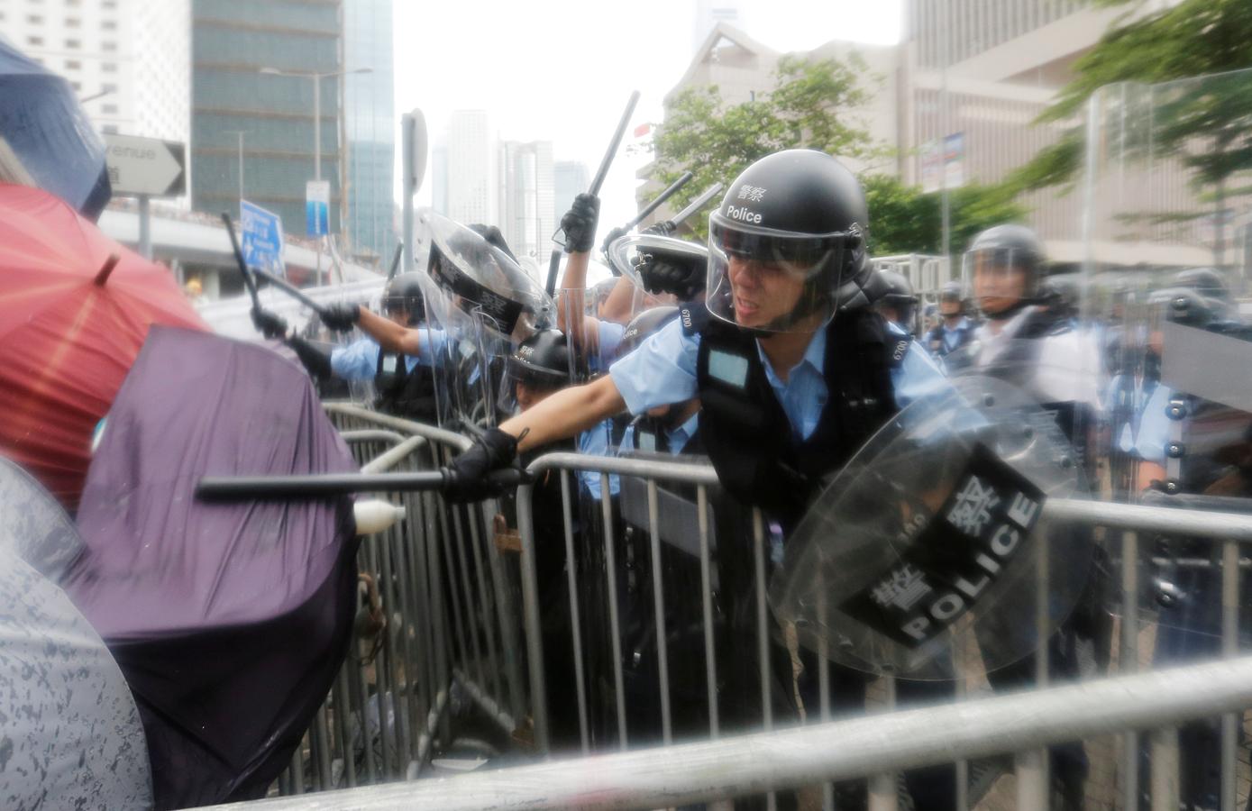 Un grupo de oficiales golpean a los manifestantes, hoy en Hong Kong.. 