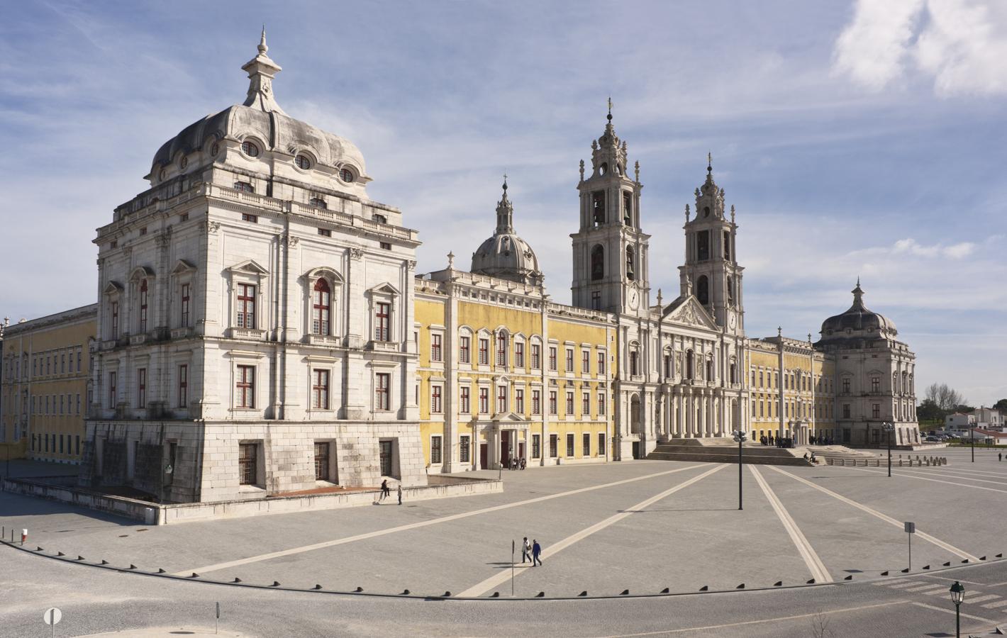 Palacio Nacional de Mafra (Portugal). Se encuentra entre las edificaciones del barroco portugués más suntuosas. El palacio fue construido a través de seis ejes simétricos, dos torres y una basílica central. El monasterio incluye una importantísima biblioteca con un fondo de 30.000 libros raros.