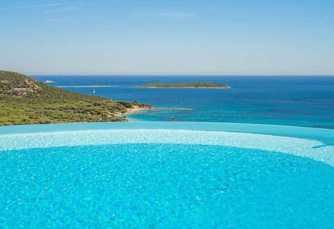 Residence Belvedere de Palombaggia, Porto Vecchio, Francia. No solo la piscina es “infinita” sino que también es desbordante (cae el agua hacia abajo). Las inmejorables vistas hacia la playa y la abundante naturaleza hacen del lugar un sitio único en el mundo, y el lugar no está tan lejos como parece… Porto Vecchio se encuentra en la isla de Córcega y esta es una de las mejores opciones para alojarse.