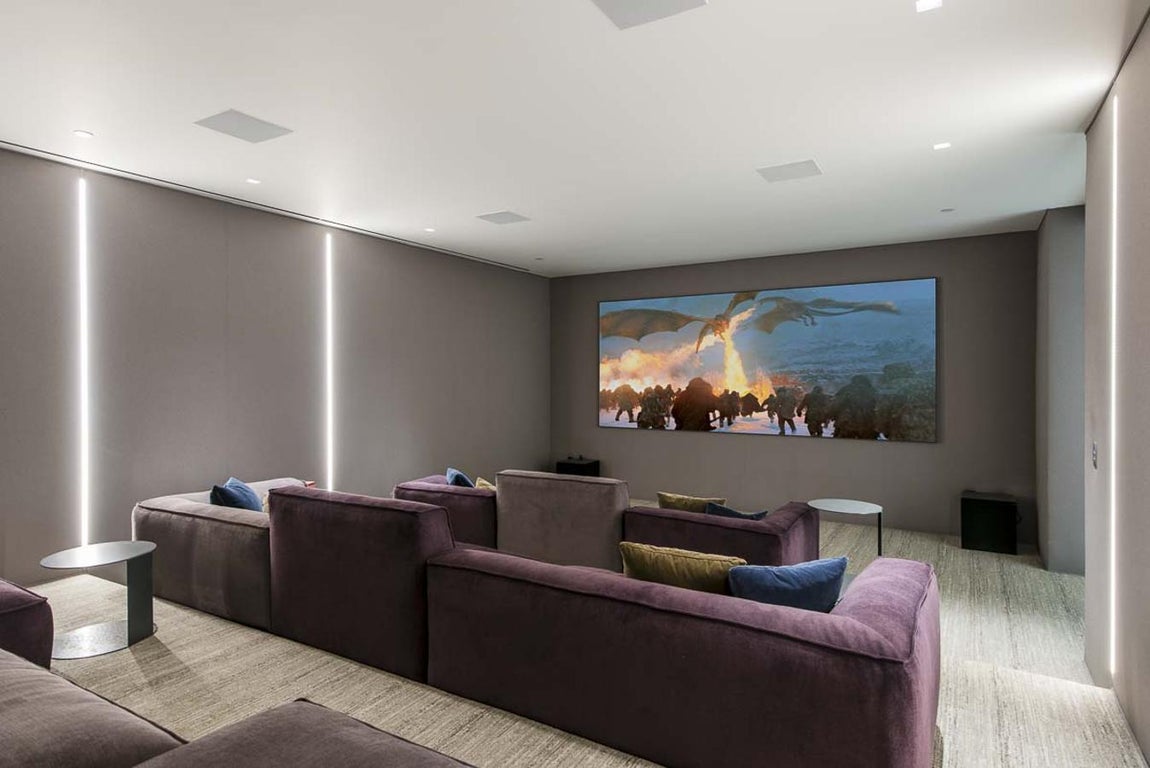 Sala de cine. Para completar este lujoso lugar, la casa tiene sala de cine, para no tener que salir de la vivienda si se quiere ver alguna película (no de estreno, por supuesto. Además, hay sala de vinos, sala de masajes, sauna y un enorme gimnasio para poder seguir manteniendo el cuerpo firme.