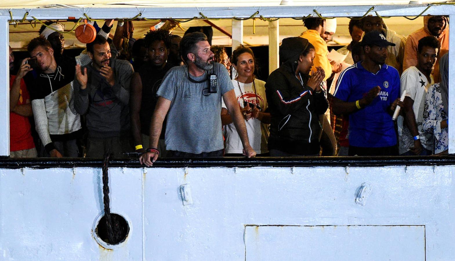 Varios voluntarios, junto a los inmigrantes en el barco de la ONG. 