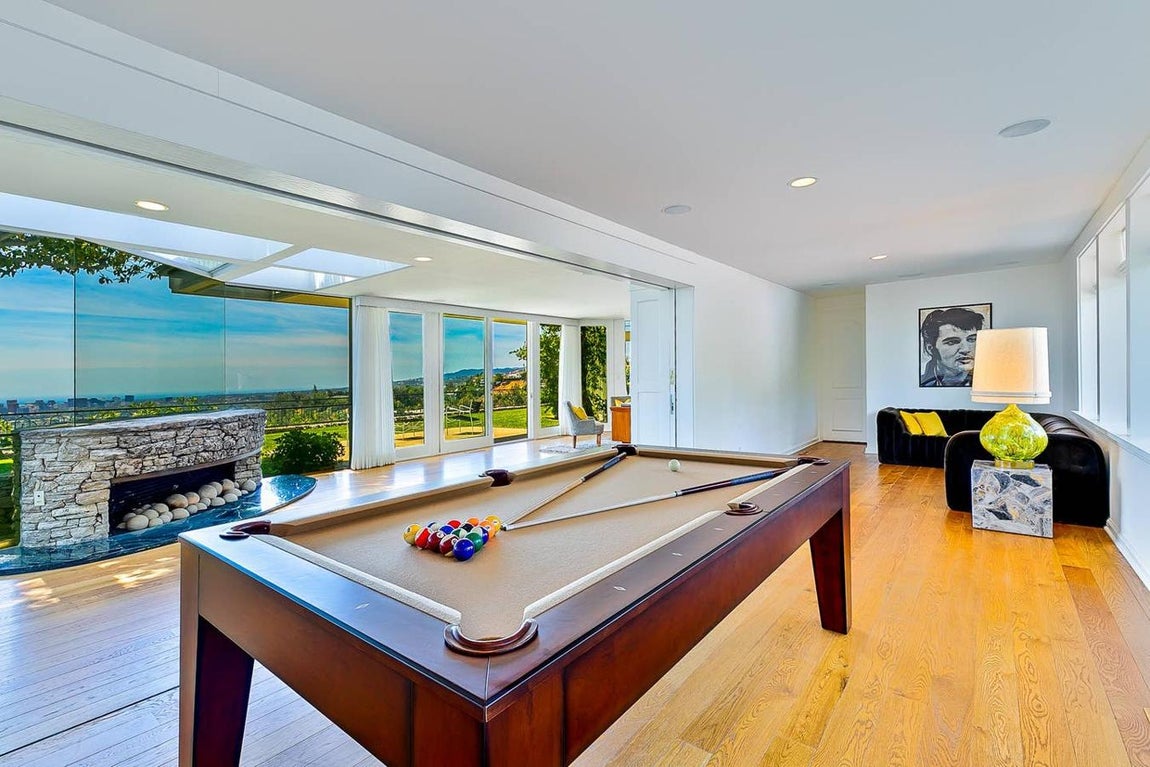 La mansión cuenta con cuatro dormitorios, entre ellos una suite de lujo, cinco baños, salón con chimenea, una bañera de hidromasaje, una sauna, un salón con paredes de vidrio y una sala de billar con vistas al valle y Mulholland Drive.