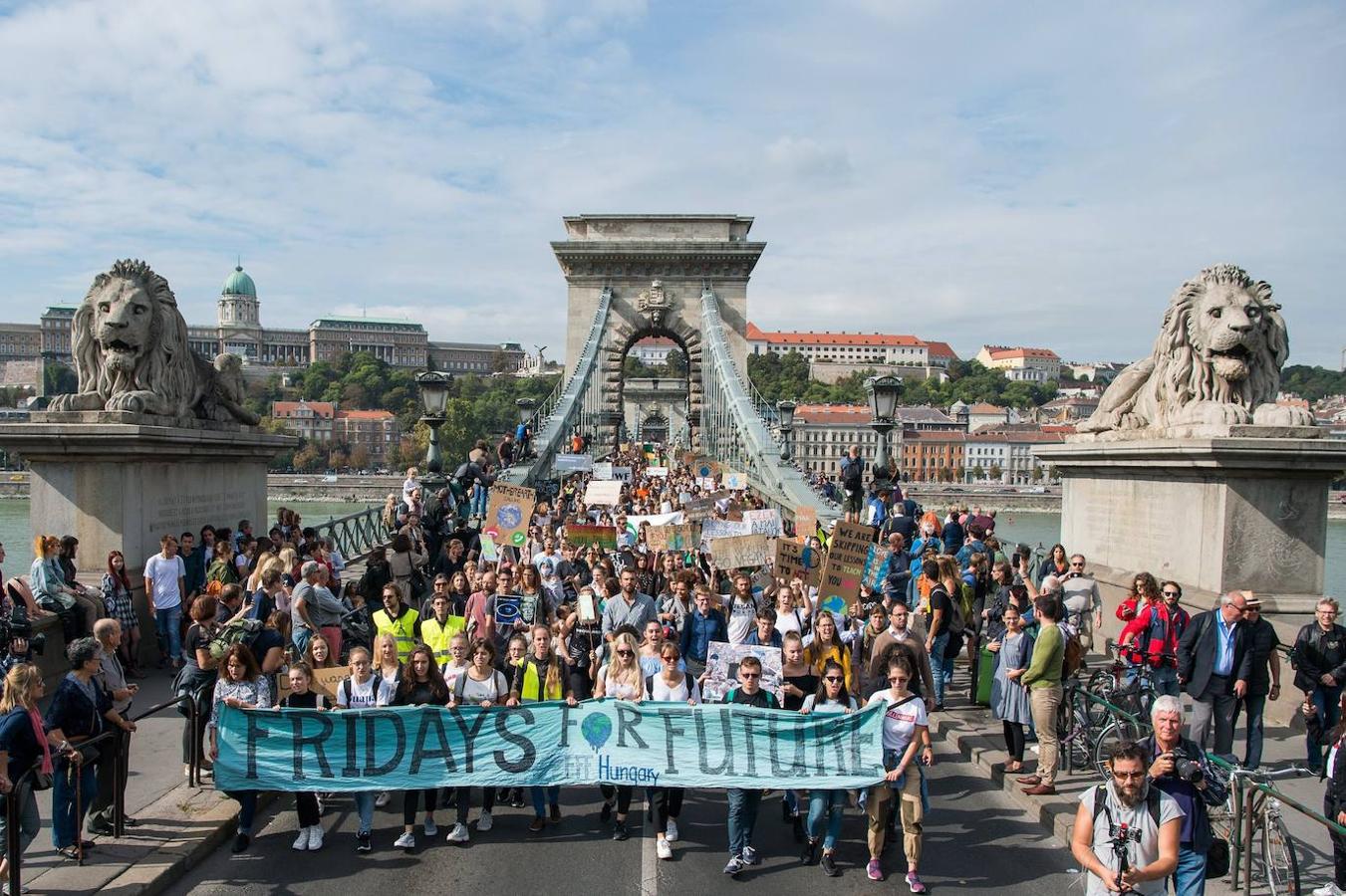 Manifestantes marchan en el Puente de las Cadenas que atraviesa el río Danubio tras la pancarta de Fridays por Future. 
