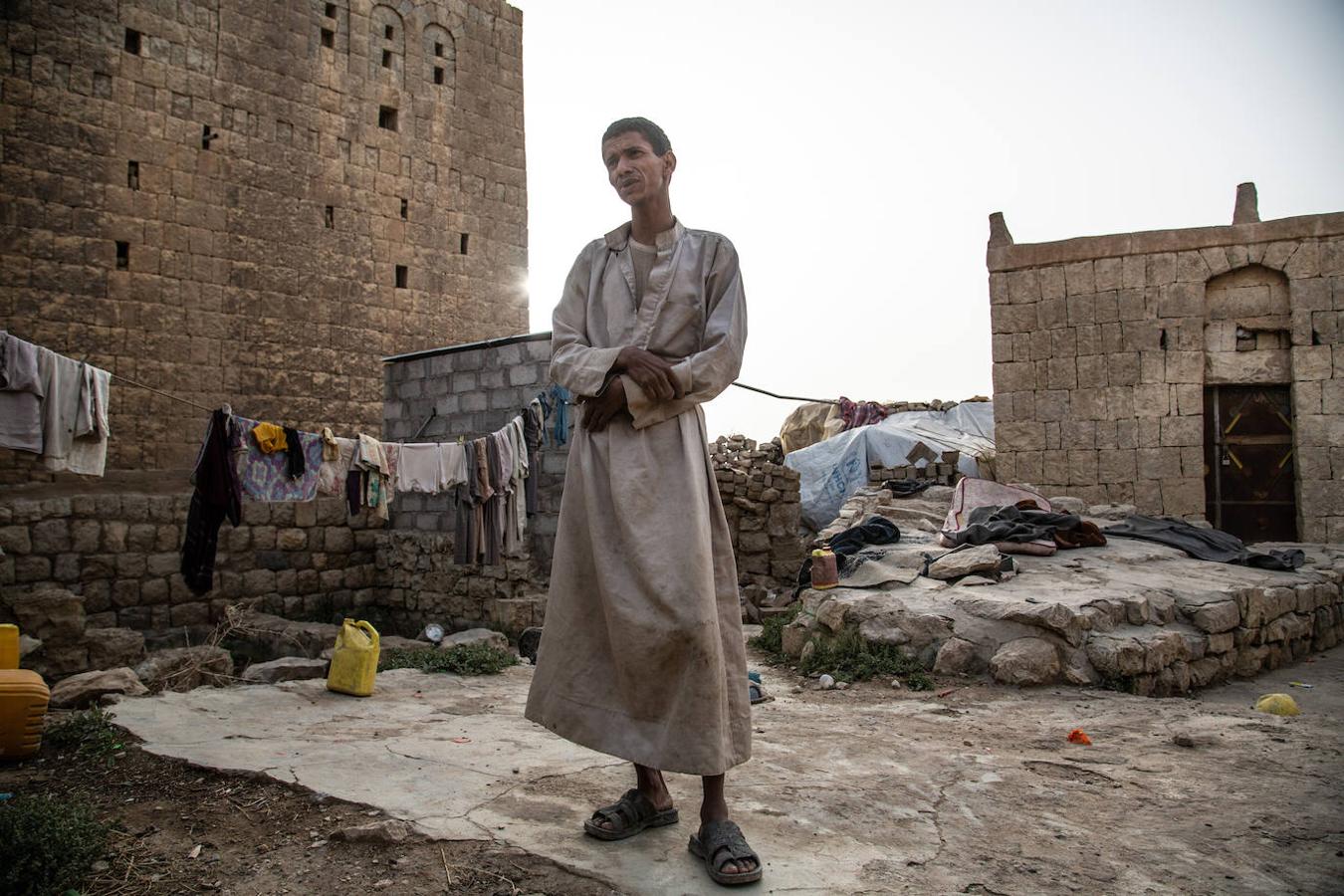 Desde la primavera pasada, Ahmad vive con su esposa y sus tres hijos en las ruinas de una antigua casa cerca de la Mezquita Khamer. Proceden de la gobernación de Hajja, de donde huyeron en abril. Antiguo comerciante, Ahmad perdió todo en los combates y bombardeos que afectaron a Kuchar, un área montañosa a unos 50 kilómetros de la frontera con Arabia Saudí. En marzo más de 5.300 familias lograron huir del distrito, pero miles más quedaron atrapadas en las zonas afectadas por los combates sin posibilidad de refugio. Según Naciones Unidas, hay unas 3,65 millones de personas desplazadas en Yemen.. 