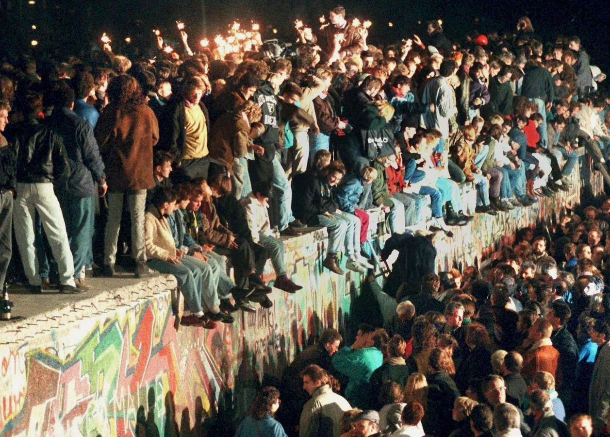 Gran número de personas celebran, con bengalas, la apertura del Muro de Berlín. EFE. 
