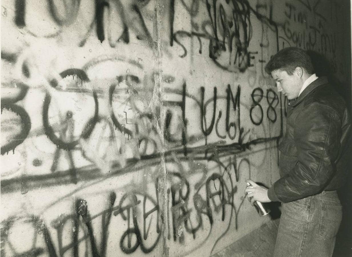 Durante la caída del muro, uno de los ciudadanos pinta los restos de la tapia. MIGUEL BERROCAL. 