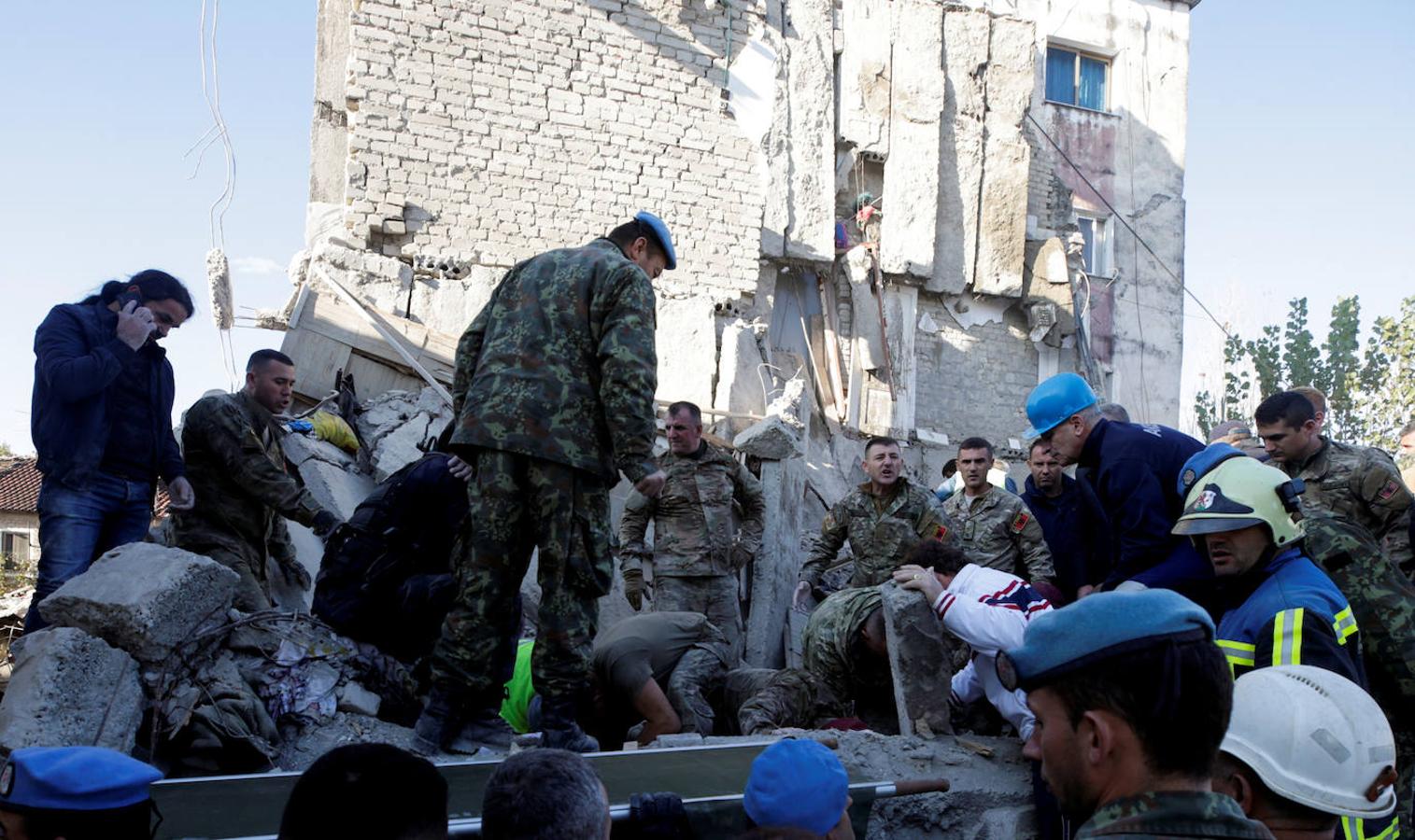 El personal militar y de emergencia trabaja cerca de un edificio dañado por el terremoto en Thumane. 