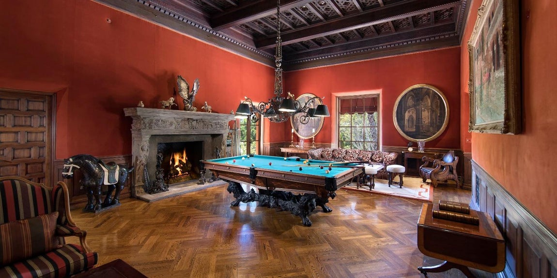 The beverly House. Algunos de los lujos más destacados de la casa son su biblioteca de dos pisos con paneles tallados a mano, una pasarela envolvente, un spa de última generación y la sala de billar con suelo de parquet en espiga. Esta estancia es la más elegante, destaca su chimenea señorial, hecha de piedra y perfilada con esculturas trabajadas a mano in situ sobre el material. En el techo también hay decoración, el periodista mandó tallar los mismos ornamentos que decoraban su castillo privado