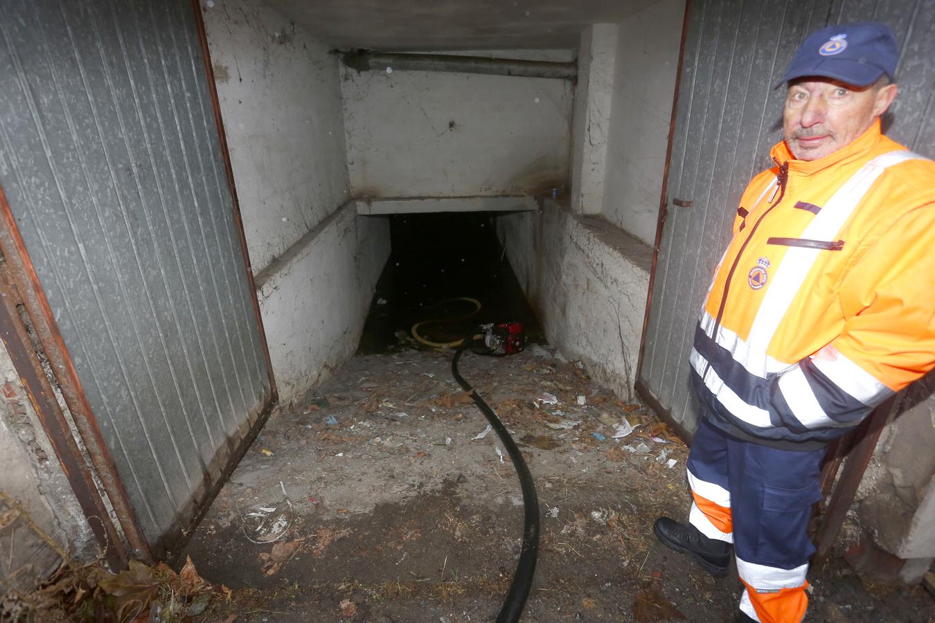 Un miembro de Protección Civil achica agua en un garaje de La Robla (León)