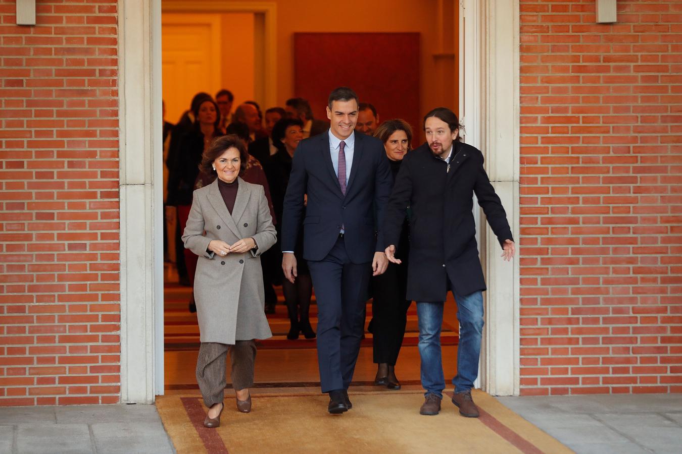 El presidente del Gobierno, Pedro Sánchez (C), camina junto a Carmen Calvo (i), y Pablo Iglesias (d), momentos antes de posar para una foto de familia del nuevo gabinete de ministros. 