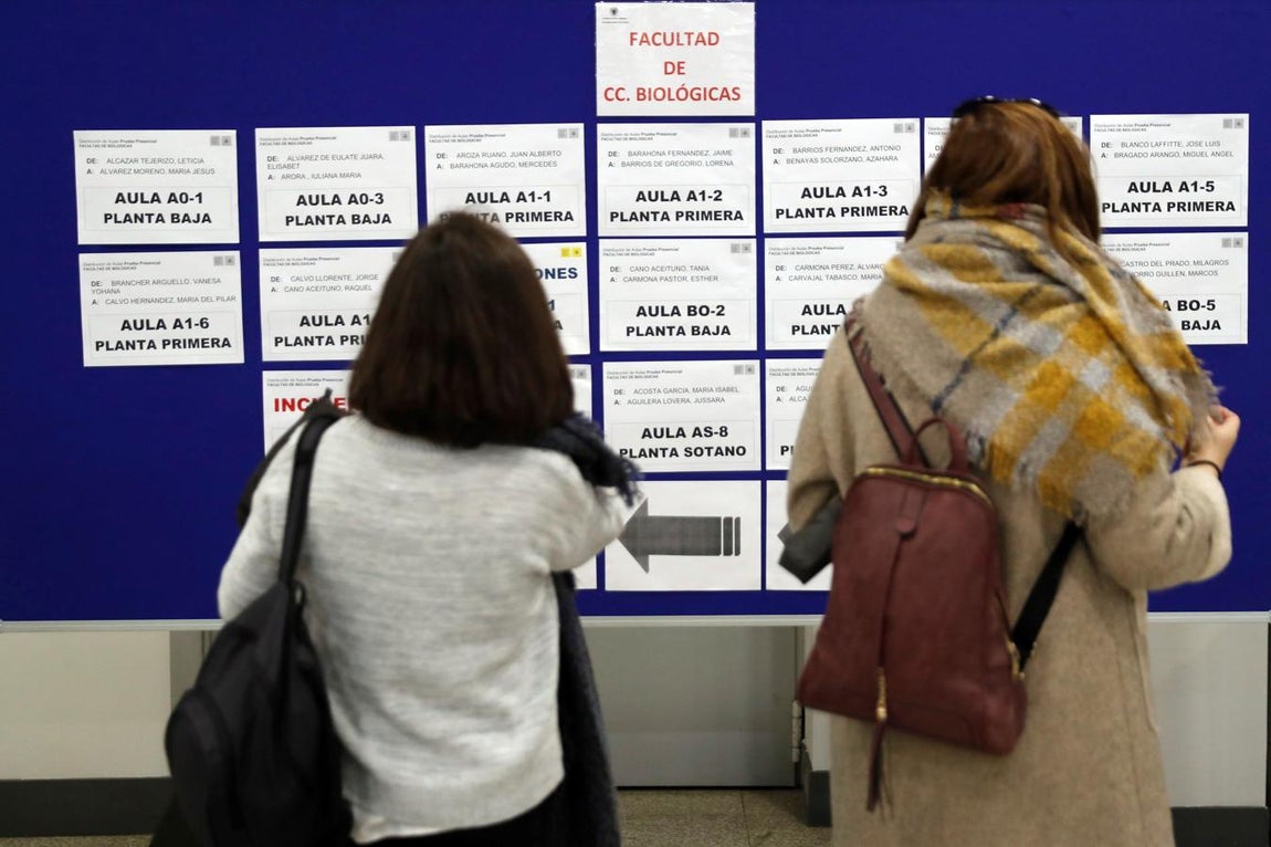 Dos mujeres consultan las aulas para realizar el examen de las oposiciones de Correos en la facultad de Ciencias Biológicas de la Universidad Complutense, en Madrid.. 