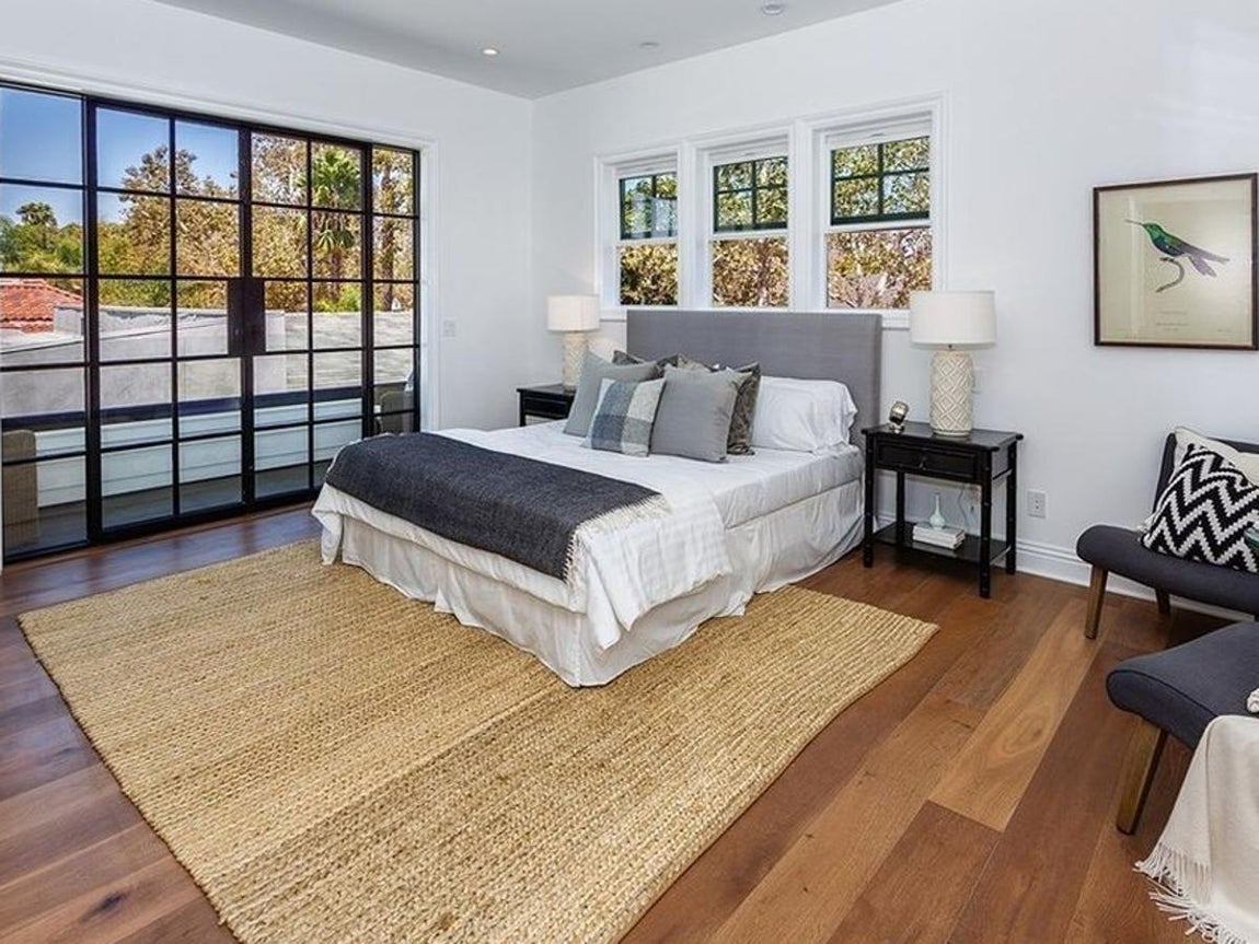 Hancock Park. El segundo dormitorio tiene prácticamente las mismas dimensiones que el primero y unas características arquitectónicas similares. La decoración también es parecida. En este caso en el cabecero de la cama hay 3 ventanas que potencian la experiencia lumínica de la habitación, pintada en un blanco pulcro,