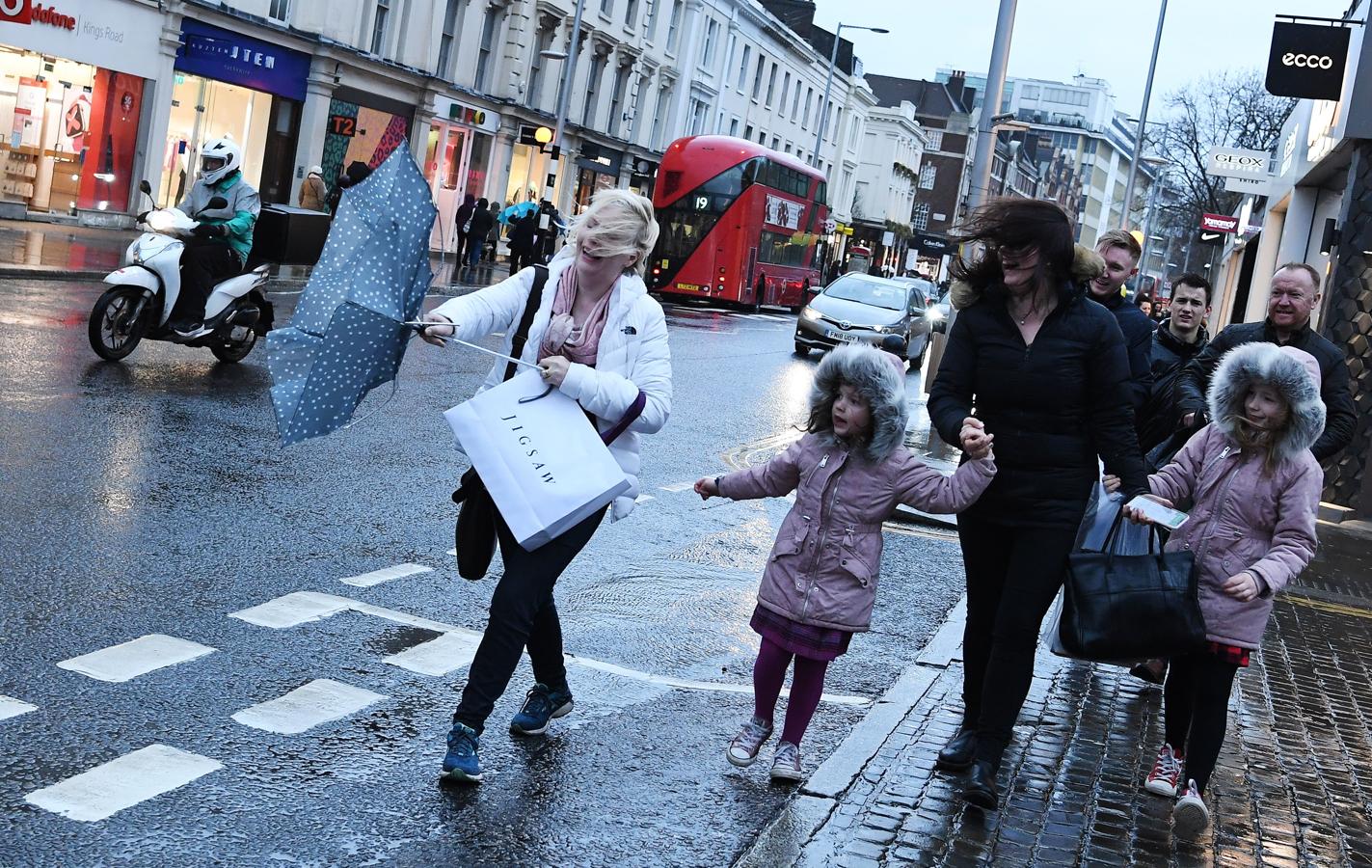 La tormenta de viento y lluvia hace sonreír a varias mujeres en Londres