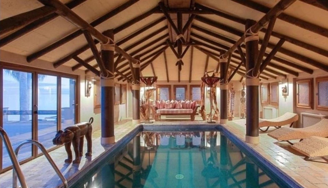 Villa de lujo en Los Monteros. Si la temperatura no acompaña, la casa tiene un salón con una enorme piscina interior. El espacio es  muy suntuoso y elegante: la piscina está flanquada por columnas de color negro, ante ella un acceso acristalado de suelo a techo al jardín. La decoración que el actual propietario eligió para su sala de baño incluye un sofá y unas sofisticadas lámparas de pie que otorgan iluminación indirecta por la noche y crean un ambiente cálido y acogedor