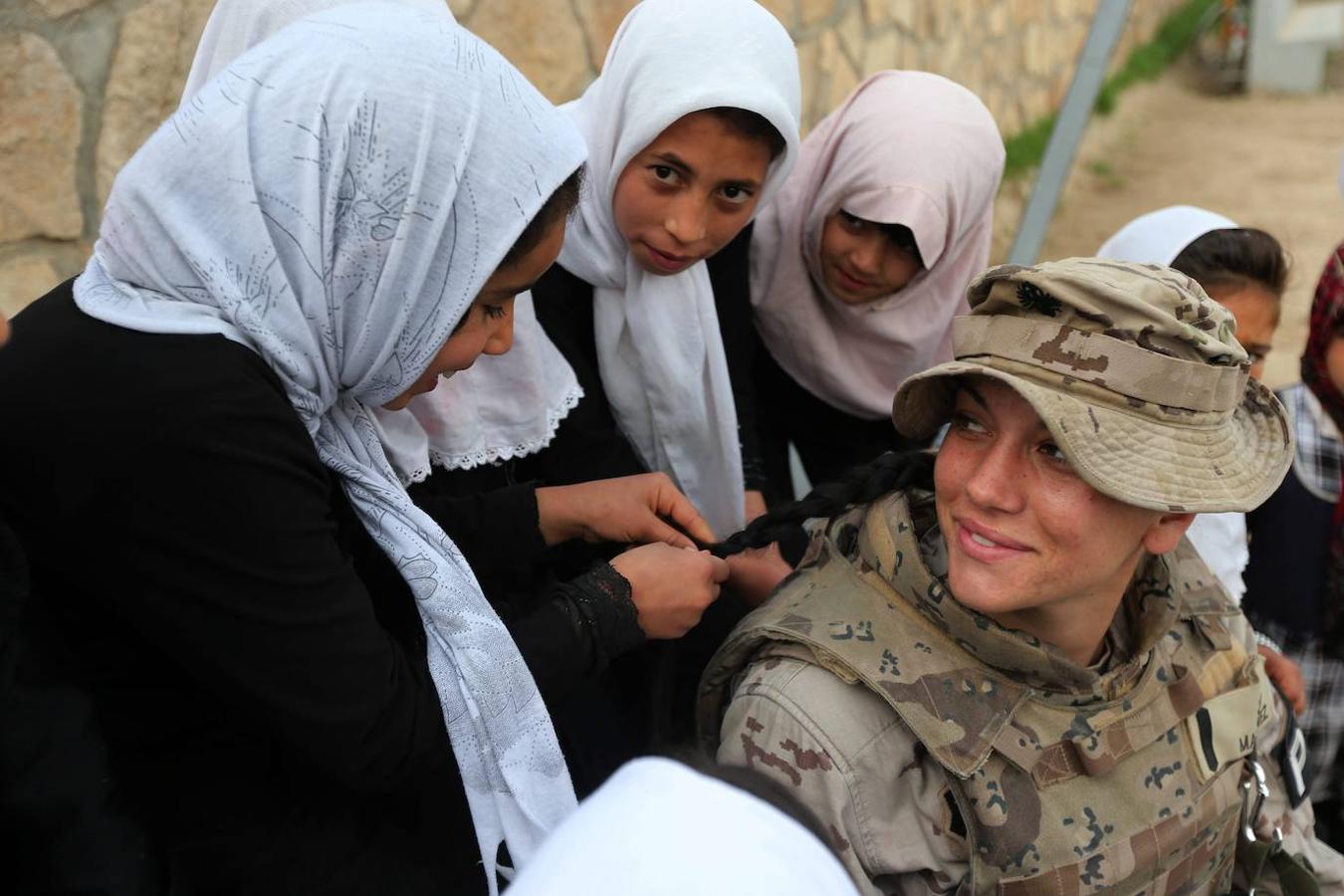 Las niñas de la escuela peinan a una de las soldado. 