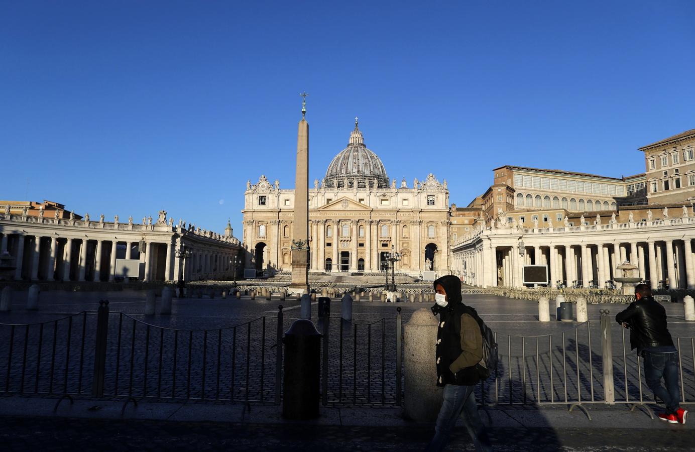 El Vaticano. Aspecto de la Plaza de San Pedro con la Basílica del mismo nombre en El Vaticano esta mañana con un transeúnte provisto de mascarilla