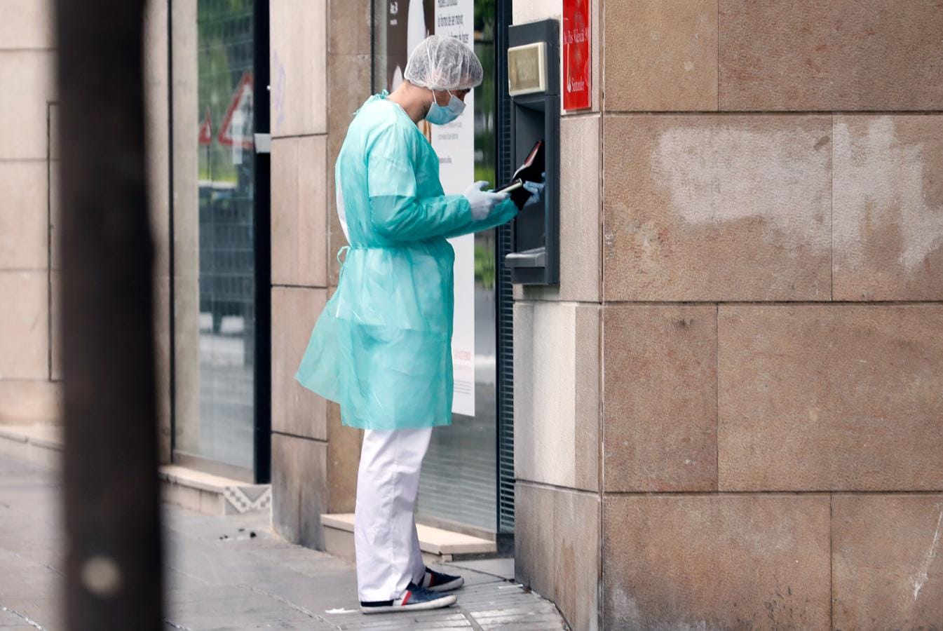 Valencia. Un hombre acude esta mañana a sacar dinero a un cajero de la capital del Turia totalmente protegido