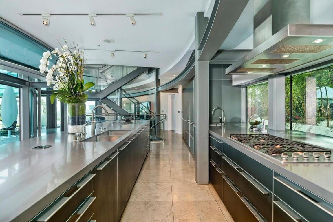 Cocina equipada al detalle. La cocina de gran tamaño incluye electrodomésticos de última generación así como una isla de gran tamaño forrada de acero inoxidable que se complementa a la perfección con la estética del exterior del edificio.