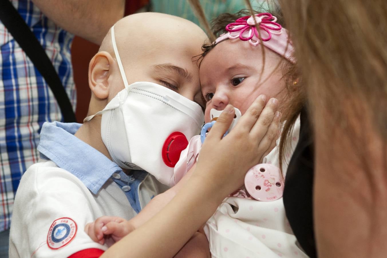 Sábado Santo. La Concepción (La Trinidad). El equipo de hematologia pediatrica del hospital Virgen del Rocio logró curar a Antonio, granadino de 6 años de edad, de una aplasia medular severa tras realizar con éxito por segunda vez en la sanidad pública un trasplante de sangre de cordón umbilical de un bebé seleccionado geneticamente, su hermana Estrella, concebida 4 meses antes.En la imagen el joven Antonio acaricia emocionado el rostro de su hermana, gracias a la cual ha salvado su vida.