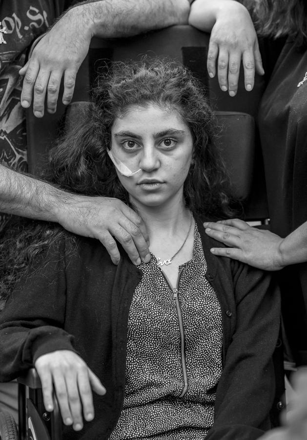 Retrato. Esta foto de Tomek Kaczor ganó el primer premio de la categoría «Retratos». Inmortaliza a Ewa, una niña armenia de 15 años que recientemente se despertó del estado catatónico provocado por la misteriosa enfermedad del Síndrome de Resignación, se sienta en una silla de ruedas, flanqueada por sus padres, en un centro de recepción de refugiados en Polonia