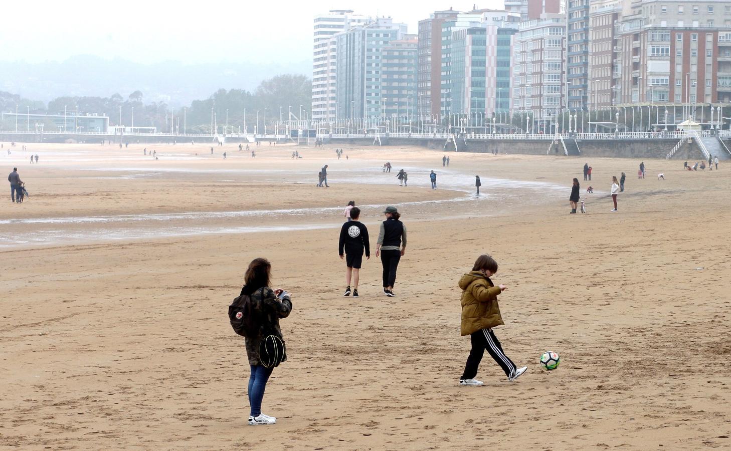 Varias personas pasean por la playa de San Lorenzo durante el cuadragésimo tercer día de estado de alarma. 